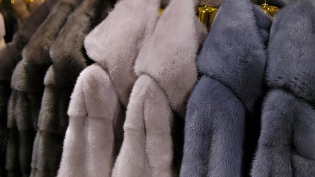 Luxury mink fur winter coat for winter sale on a clothes rack in a retail fashion store. Close up.