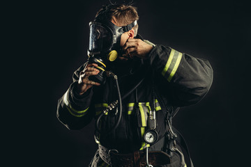 Fototapeta na wymiar strong firefighter in protective suit and helmet use special equipment for preventing fire and save people and animals from fire