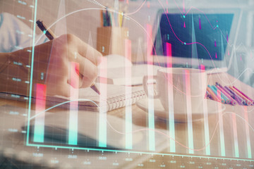 Financial chart drawn over hands taking notes background. Concept of research. Double exposure