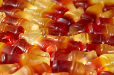 Cola flavored gummy jellies in the shape of cola bottles,background image. Horizontal.