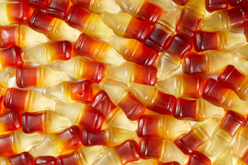 Cola flavored gummy jellies in the shape of cola bottles,background image. Top view.