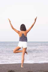 Fototapeta na wymiar Young athlete woman practicing yoga on the beach