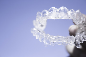 Invisible dental braces held by woman hand