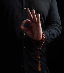 man in a black shirt shows with his left hand the gian mudra