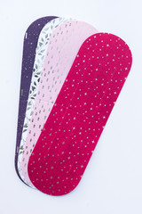 Cut out paper for braiding Christmas hearts. Red, pink, white and grey colored paper with gold paterns on. Image to use for instructions for DIY holiday ideas.