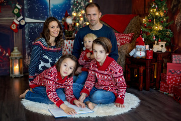 Fototapeta na wymiar Happy smiling family, mom, dad and three boys, having family portrait at home for Christmas