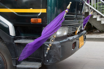 Closeup view of decorative flags fluttering on the front of a truck while driving through the city...