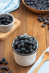 Ripe blueberries in the bowl on the wooden table. Fresh berries for breakfast.