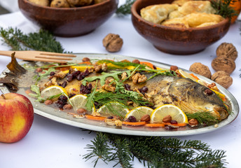 carp with lemon, walnuts and raisins on the plate
