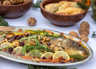 carp with lemon, walnuts and raisins on the plate