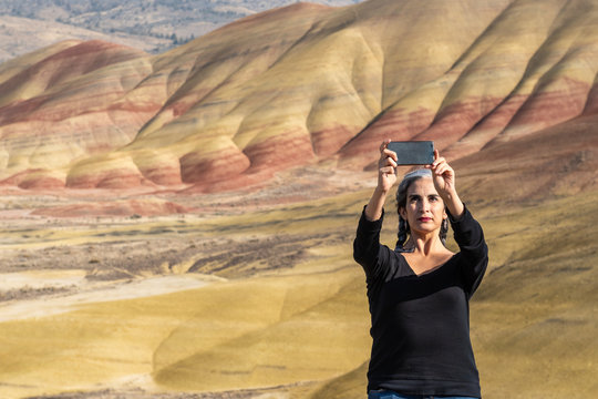 A young brunette with gray strands takes selfies at Painted Hills Overlook