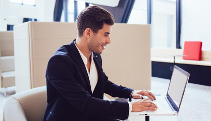 Laughing employee working with laptop in office