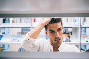 Frustrated student searching book in library