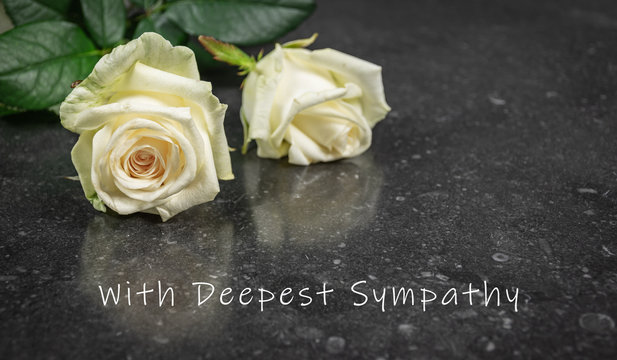 Sympathy photo card with two white roses on dark background.