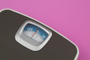 Scale on pink background with space for text. Loose weight and overweight concept.