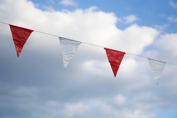 Hanging party flags sky with clouds background