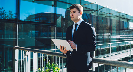 Creative formal man with tablet
Handsome pensive businessman in suit using tablet with stylus while...