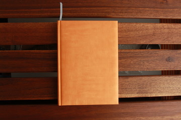 book with orange cover on wooden background