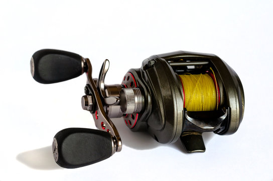 Low Profile Baitcasting Reel. Close-up of a fishing reel with yellow fishing line. Isolate on a white background. Selective focus. Front view
