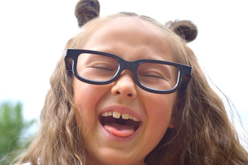 Portrait of beautiful young first-grader girl in eyeglasses. Focus on girls eyes