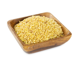 Bulgur wheat in wooden bowl isolated on white