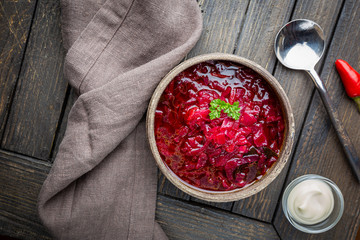 Traditional Ukrainian Russian vegetable beet soup, borscht on wooden background, top view