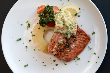 Top view caramelized Pineapple salmon fillet with celery served on a white plate