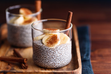 Chia pudding with coconut milk and banana in glasses on a table. Vegetarian healthy dessert.