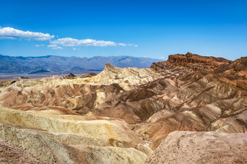 Zabriskie Point, surrounded by a maze of wildly eroded and vibrantly colored badlands in Death Valley, USA