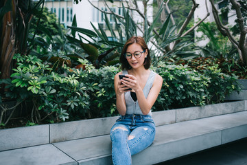 Woman using smartphone sitting on bench