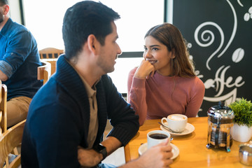Smiling Lovers Enjoying Coffee At Cafe