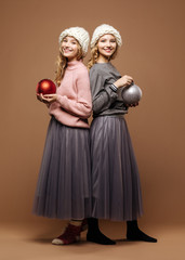 Cute happy twins with a baubles on brown background