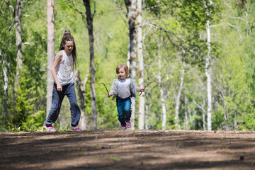 Children walk and have fun in the forest on summer day.