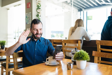 Male Doing Video Call On Smartphone While Having Coffee At Cafe