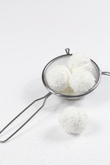 Fototapeta na wymiar Coconut Marshmallows Balls in a silver sieve, on white background.
