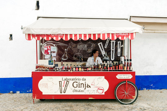 OBIDOS, PORTUGAL - SEPTEMBER 8, 2015: Roll Stand with different cherry liqueur on the streets of Obidos. Obidos known ginjinha produced here (the traditional Portuguese cherry liqueur).