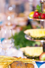 Blurred background of a banquet table with buns in the foreground.