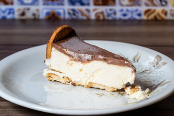 pedaço de torta holandesa gelada em pires colorido sobre mesa de madeira