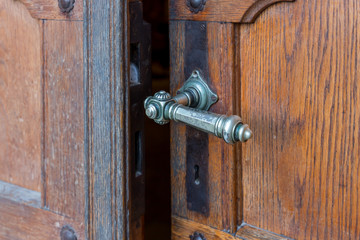 Obraz premium Decorative bronze handle on the front door in the interior of the Benedictine Abbey of Abu Gosh in the Chechen village Abu Ghosh near Jerusalem in Israel