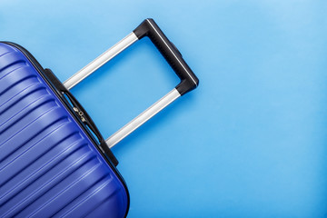 Modern Phantom Blue classic blue suitcase on blue background close up with copy space for text....