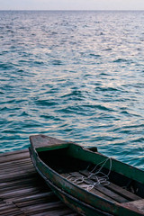Obraz premium Old wooden boat sitting on the pier overlooking the beautiful Semporna turquoise sea.
