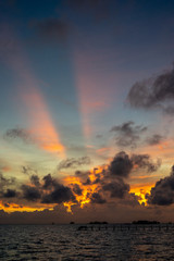 Sunset background and sun beam on the open sea with beautiful clouds.