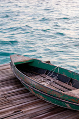 Old wooden boat sitting on the pier overlooking the beautiful Semporna turquoise sea.