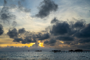 Sunset background and sun beam on the open sea with beautiful clouds.