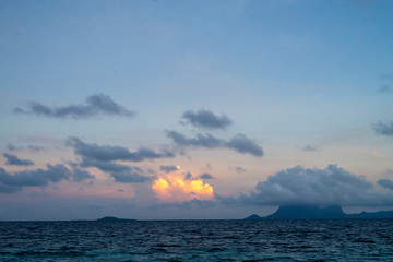 Sunset background and sun beam on the open sea with beautiful clouds.