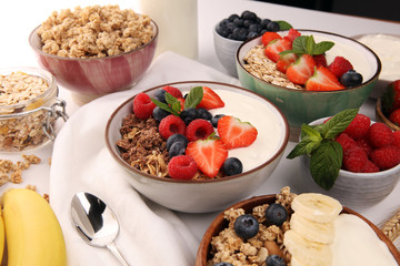Tasty homemade granola served on table. Healthy breakfast with a bowl of oatmeal with banana, blueberries, strawberries and healthy food for Breakfast