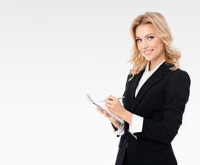 Portrait of young beautiful businesswoman in black confident suit, with clipboard writing, isolated...