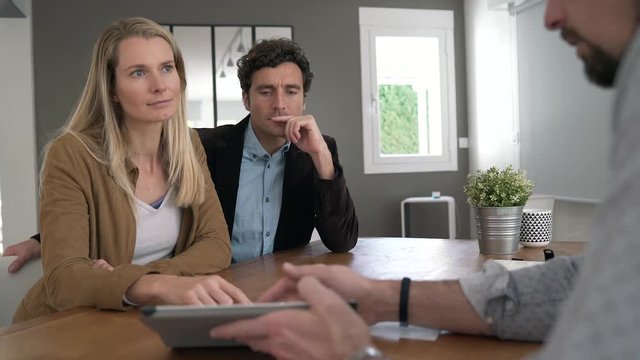 Businessman showing real-estate project to couple of clients