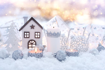 Christmas composition with candles and festive decorations оn the snow. Christmas or New Year greeting card.