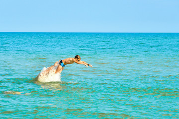 Children jump on the sea, family holidays with children on vacation. The father throws the child up in the water.
